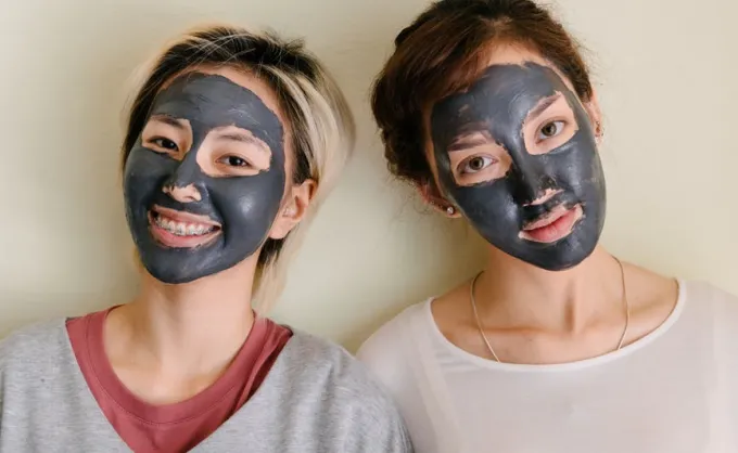 Dua perempuan menggunakan masker